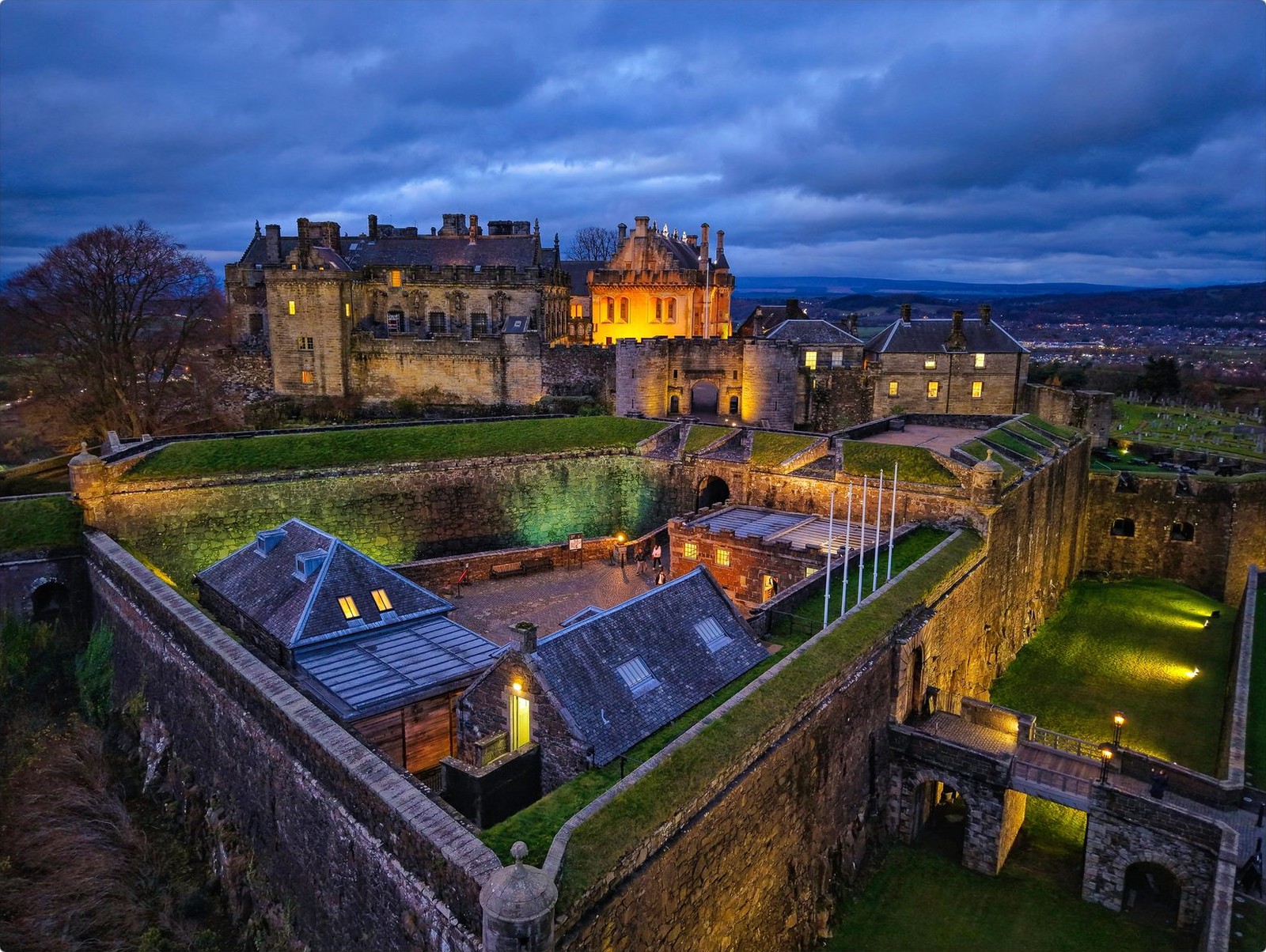 Stirling Castle floodlit at blue hour, seen from above